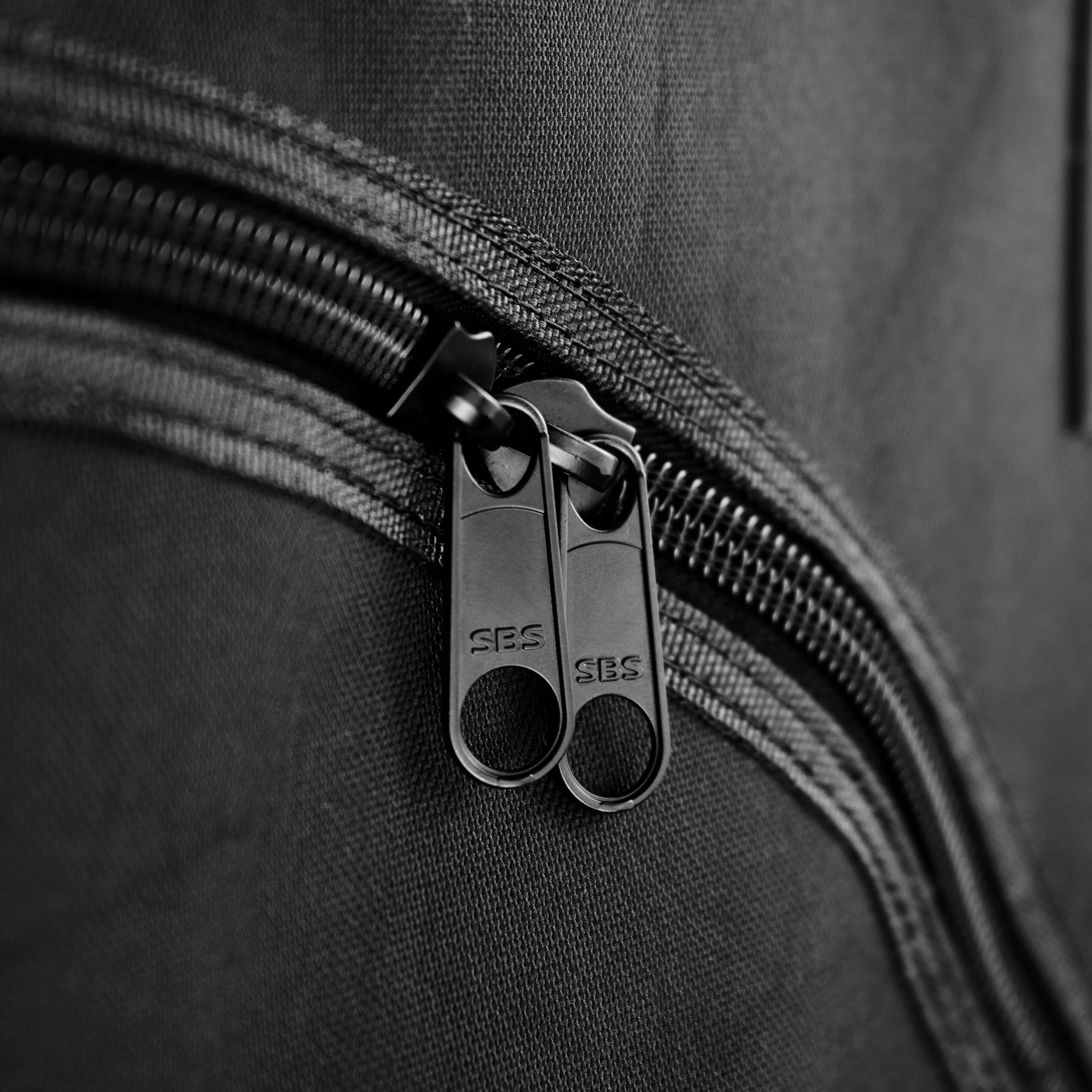 Nahaufnahme eines schwarzen Reißverschlusses mit zwei Zippern auf Stoffmaterial.